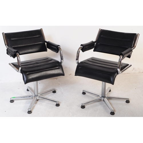 698 - A pair of vintage mid 20th century metal and leatherette chrome office swivel desk chairs. Having a ... 
