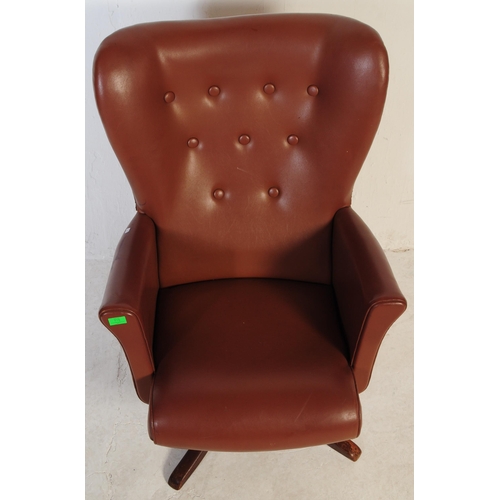 710 - A retro mid 20th century batwing swivel armchair / chair. In the manner of G-Plan being raised on a ... 
