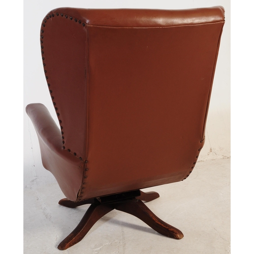 710 - A retro mid 20th century batwing swivel armchair / chair. In the manner of G-Plan being raised on a ... 