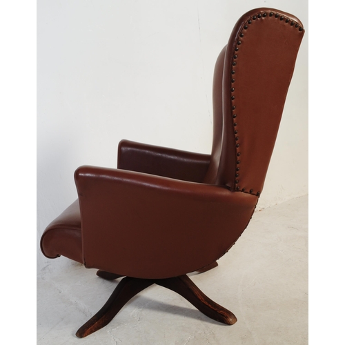 710 - A retro mid 20th century batwing swivel armchair / chair. In the manner of G-Plan being raised on a ... 