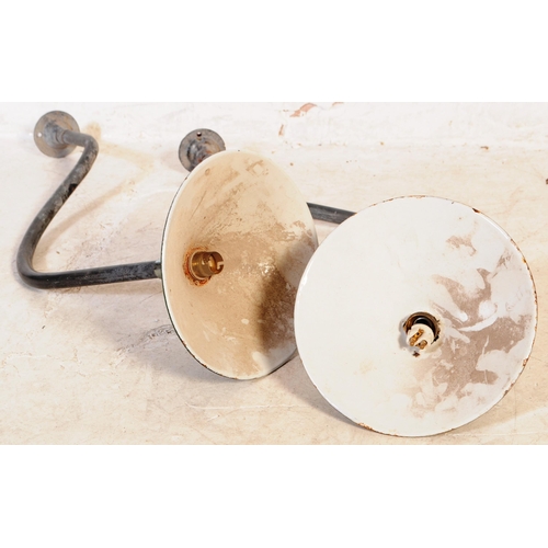 607 - A pair of Industrial mid century yard lamps. Each on tubular metal swan neck wall mounts having gree... 