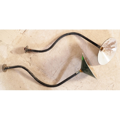 607 - A pair of Industrial mid century yard lamps. Each on tubular metal swan neck wall mounts having gree... 