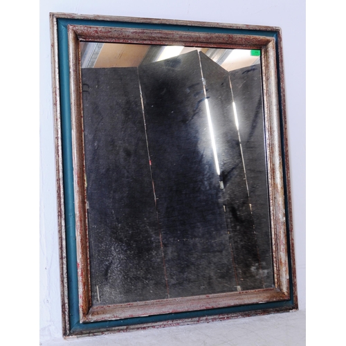 656 - A 20th century silvered and green painted frame mirror. The mirror with cushioned frame having a sil... 