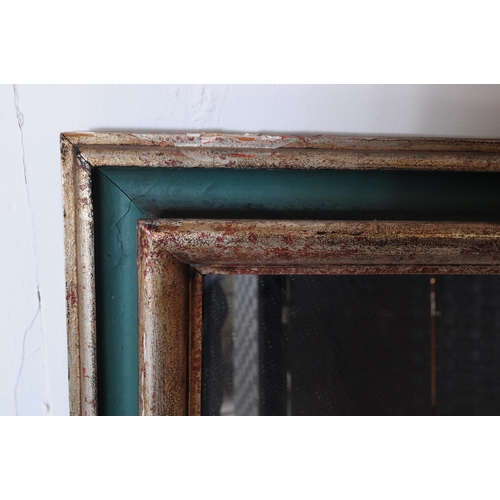 656 - A 20th century silvered and green painted frame mirror. The mirror with cushioned frame having a sil... 