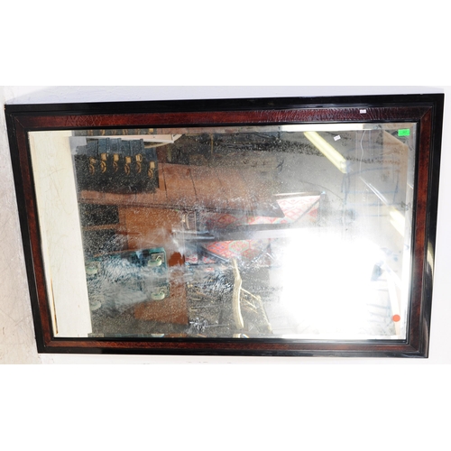 667 - A large 20th century ebonised and lacquered frame mirror. The mirror with beveled edge two tone lacq... 