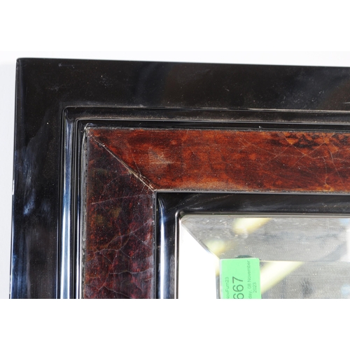 667 - A large 20th century ebonised and lacquered frame mirror. The mirror with beveled edge two tone lacq... 