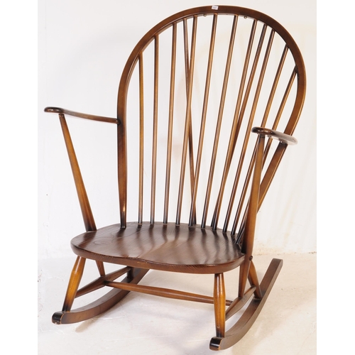 654 - Ercol Furniture - A vintage 20th century dark elm stick back Windsor rocking chair. Arched back rest... 