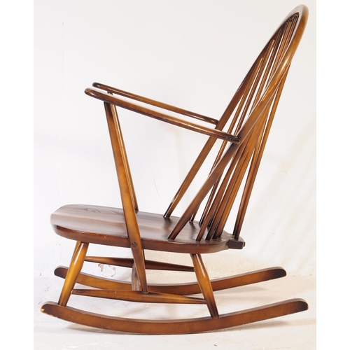 654 - Ercol Furniture - A vintage 20th century dark elm stick back Windsor rocking chair. Arched back rest... 