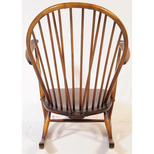 654 - Ercol Furniture - A vintage 20th century dark elm stick back Windsor rocking chair. Arched back rest... 