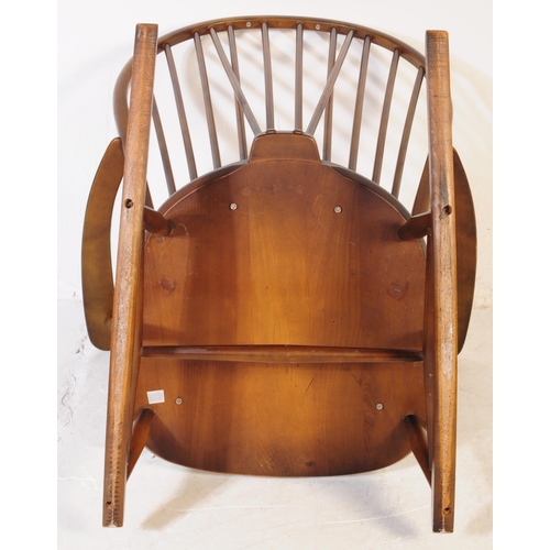 654 - Ercol Furniture - A vintage 20th century dark elm stick back Windsor rocking chair. Arched back rest... 