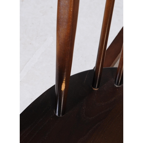 654 - Ercol Furniture - A vintage 20th century dark elm stick back Windsor rocking chair. Arched back rest... 