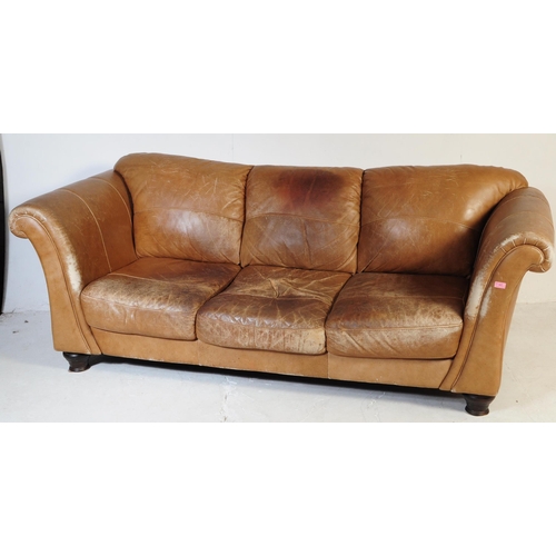655 - A 20th Century beige / brown leather three seater sofa settee and matching arm chair. Having scrolle... 