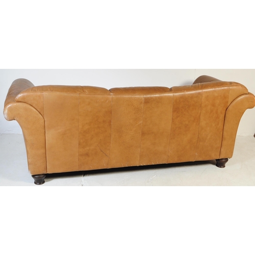 655 - A 20th Century beige / brown leather three seater sofa settee and matching arm chair. Having scrolle... 