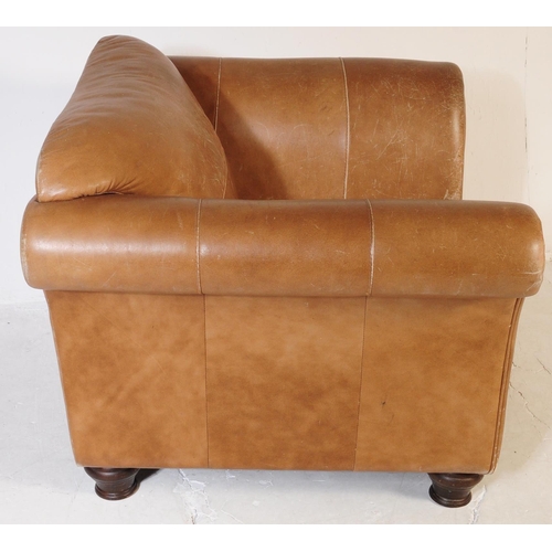 655 - A 20th Century beige / brown leather three seater sofa settee and matching arm chair. Having scrolle... 