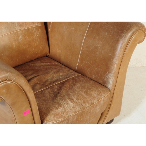 655 - A 20th Century beige / brown leather three seater sofa settee and matching arm chair. Having scrolle... 