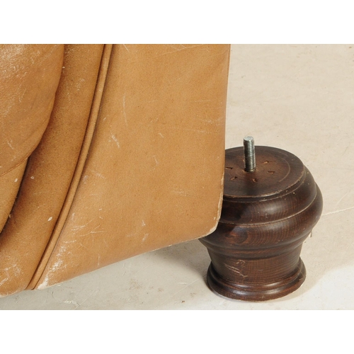 655 - A 20th Century beige / brown leather three seater sofa settee and matching arm chair. Having scrolle... 