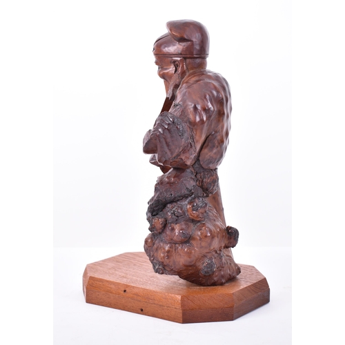 114 - A 20th century Chinese hand carved root wood deity of Prosperity figure. The sculpture modelled with... 