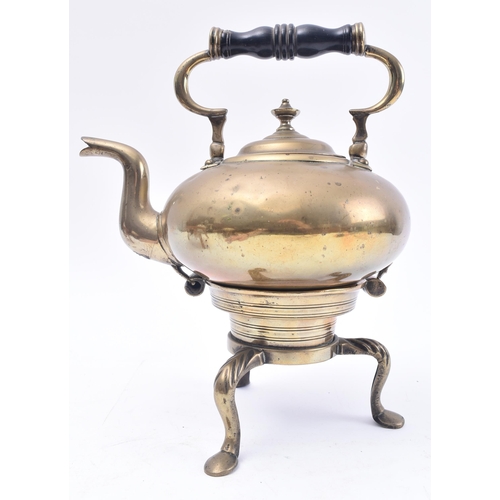 119 - An 18th century brass toddy kettle on stand. The kettle having a turned ebony baluster handle over a... 