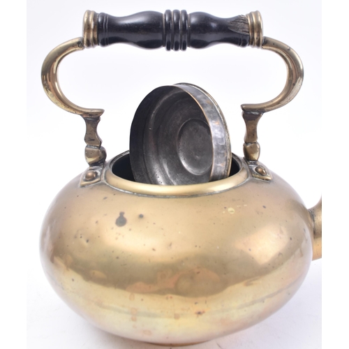 119 - An 18th century brass toddy kettle on stand. The kettle having a turned ebony baluster handle over a... 