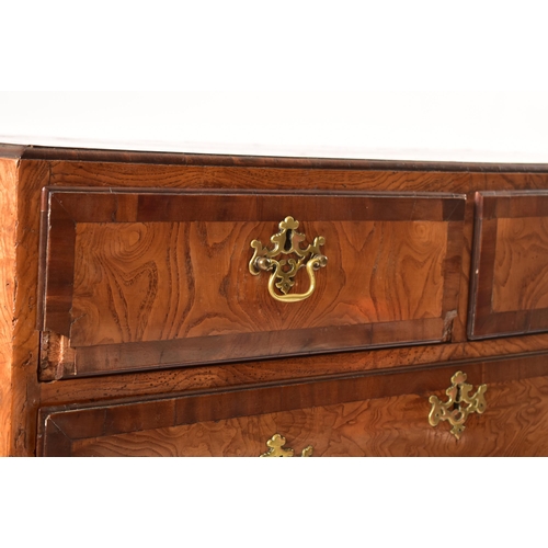 12 - An 18th century Queen Anne pollard oak crossbanded chest of drawers. Raised on bracket feet with sho... 