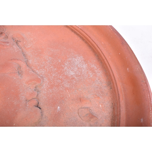 138 - A late 19th century Victorian terracotta circular garden wall plaque. The plaque having a cushioned ... 