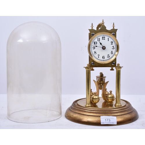 173 - A 19th century German Torsion Anniversary clock. The brass clock with swing pendulum raised on porti... 