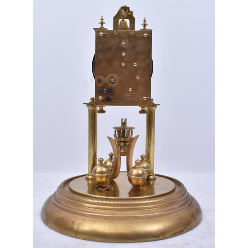 173 - A 19th century German Torsion Anniversary clock. The brass clock with swing pendulum raised on porti... 