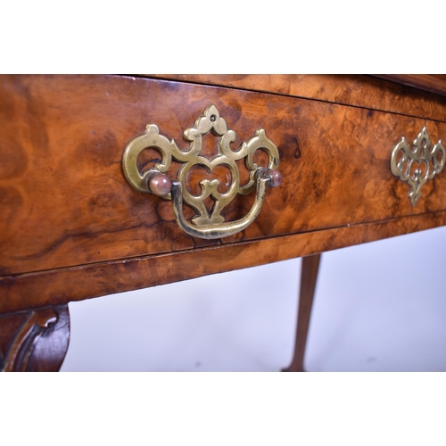 197 - A Queen Anne walnut revival silver table. Raised on cabriole legs with claw and ball feet having fit... 