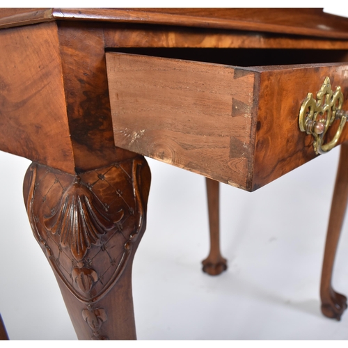 197 - A Queen Anne walnut revival silver table. Raised on cabriole legs with claw and ball feet having fit... 