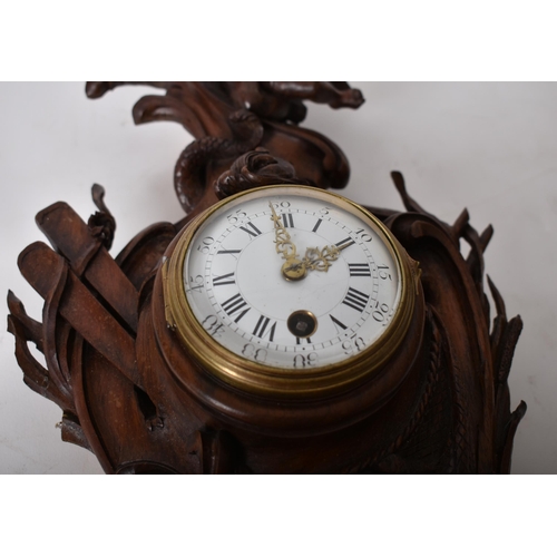 22 - A 19th century carved oak Black Forest wall clock. The clock with carved rococo body with cherub and... 