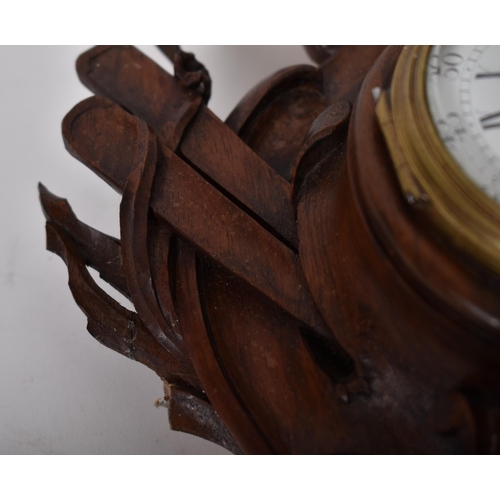 22 - A 19th century carved oak Black Forest wall clock. The clock with carved rococo body with cherub and... 