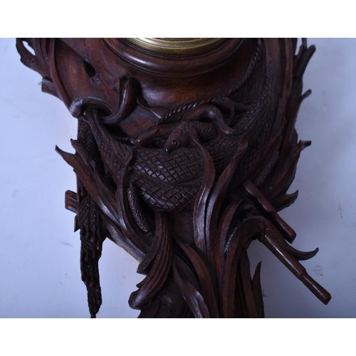 22 - A 19th century carved oak Black Forest wall clock. The clock with carved rococo body with cherub and... 