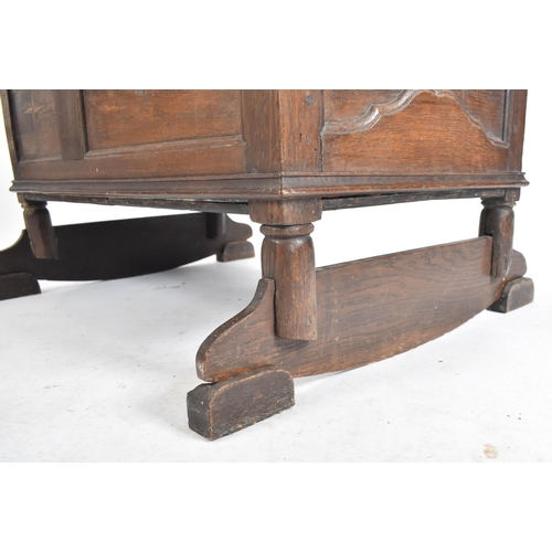 220 - A 17th century country carved oak crib - bed. The crib with sleigh rockers with inset fielded panel ... 