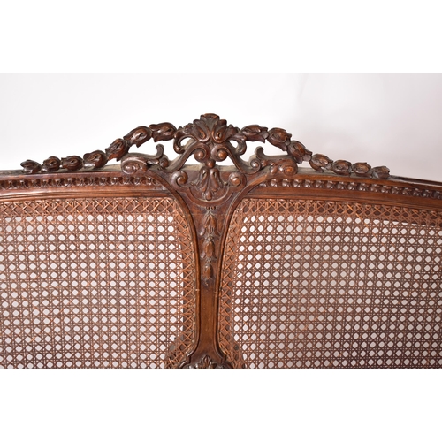 222 - An early 20th century carved walnut & wicker double bed frame. The frame having a hand carved one pi... 