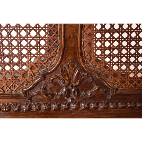 222 - An early 20th century carved walnut & wicker double bed frame. The frame having a hand carved one pi... 