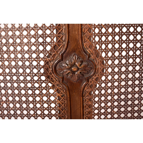 222 - An early 20th century carved walnut & wicker double bed frame. The frame having a hand carved one pi... 