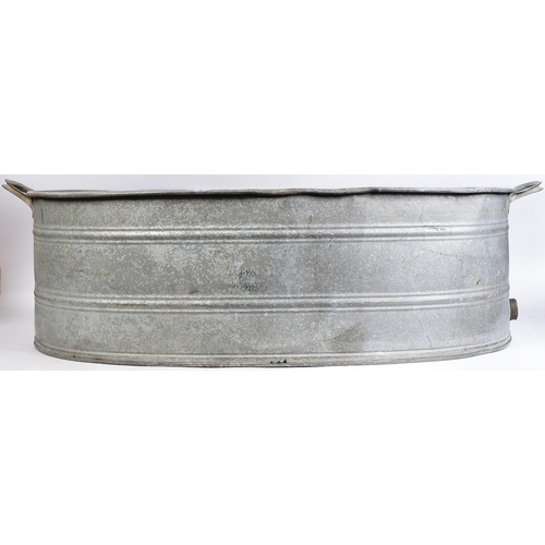 227 - An early 20th century large oval galvanised tin bath. Of oval form, with handles to either side and ... 