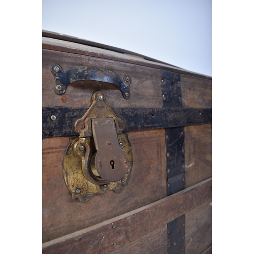 263 - A 19th century dome top wooden and metal bound steamer trunk. The wooden body with ebonised metal st... 