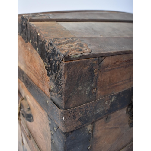 263 - A 19th century dome top wooden and metal bound steamer trunk. The wooden body with ebonised metal st... 