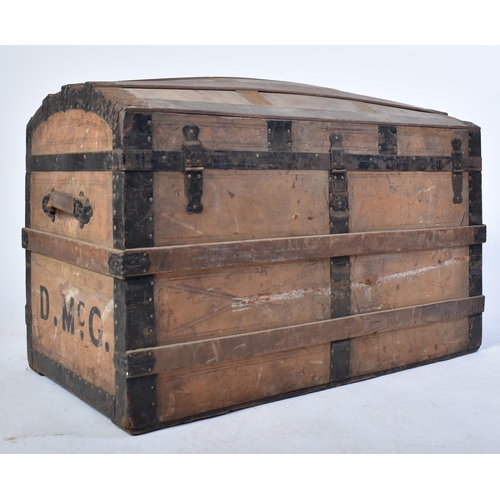 263 - A 19th century dome top wooden and metal bound steamer trunk. The wooden body with ebonised metal st... 