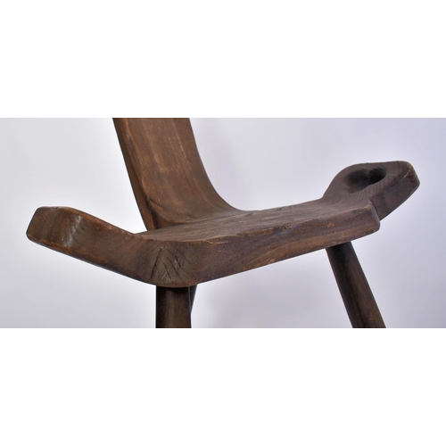 303 - A late 19th century Brutalist elm wood birthing milking tripod stool / chair. The stool having a han... 