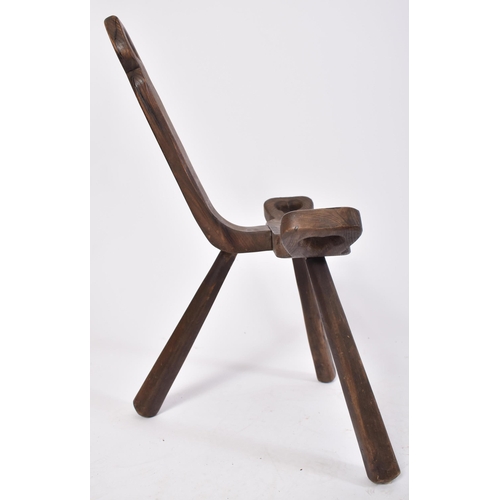 303 - A late 19th century Brutalist elm wood birthing milking tripod stool / chair. The stool having a han... 