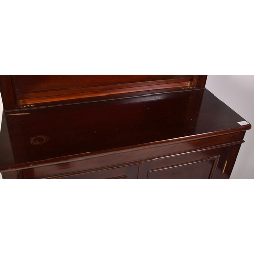 398 - A pair of tall early 20th century Victorian style mahogany bookcase cabinets. Each having a pediment... 