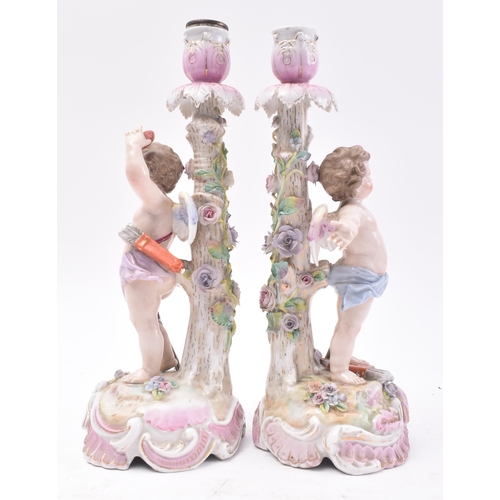 477 - A pair 19th century German Sitzendorf hand painted porcelain cherub - putti candlesticks. Each holde... 