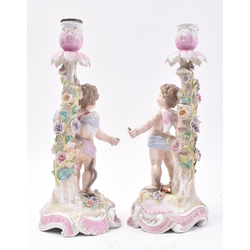 477 - A pair 19th century German Sitzendorf hand painted porcelain cherub - putti candlesticks. Each holde... 