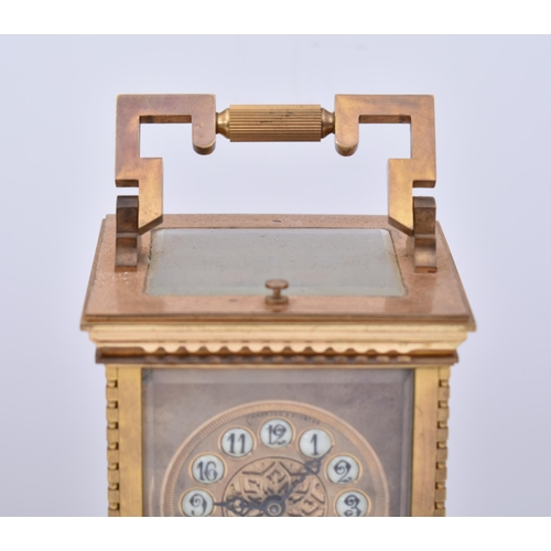 56 - A 20th century brass repeating carriage clock. The desk clock with brass edges & handle and bevelled... 