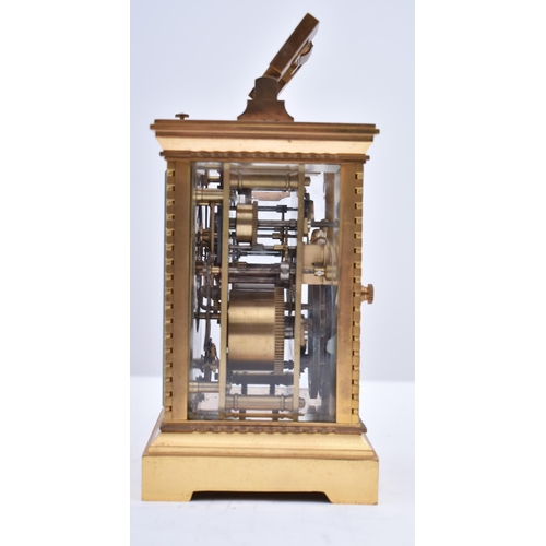 56 - A 20th century brass repeating carriage clock. The desk clock with brass edges & handle and bevelled... 