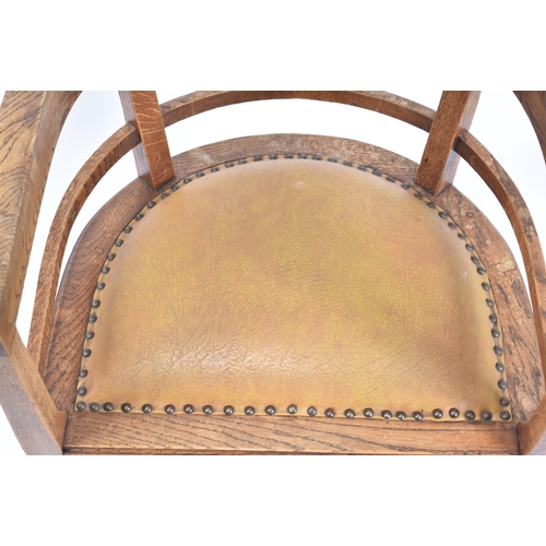 59 - An early 20th century circa 1920s elm wood tub office chair. The chair having a tub shaped back scro... 