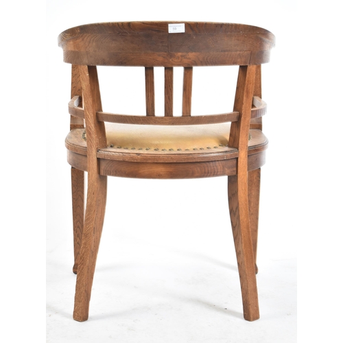 59 - An early 20th century circa 1920s elm wood tub office chair. The chair having a tub shaped back scro... 