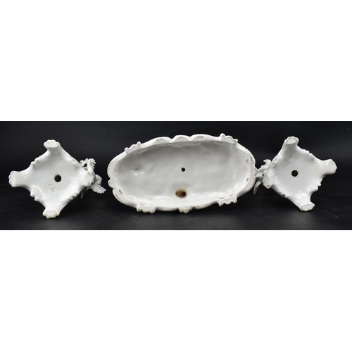 67 - A 19th century Triade PBB white porcelain glaze garniture - diorama of winged putti. The central put... 